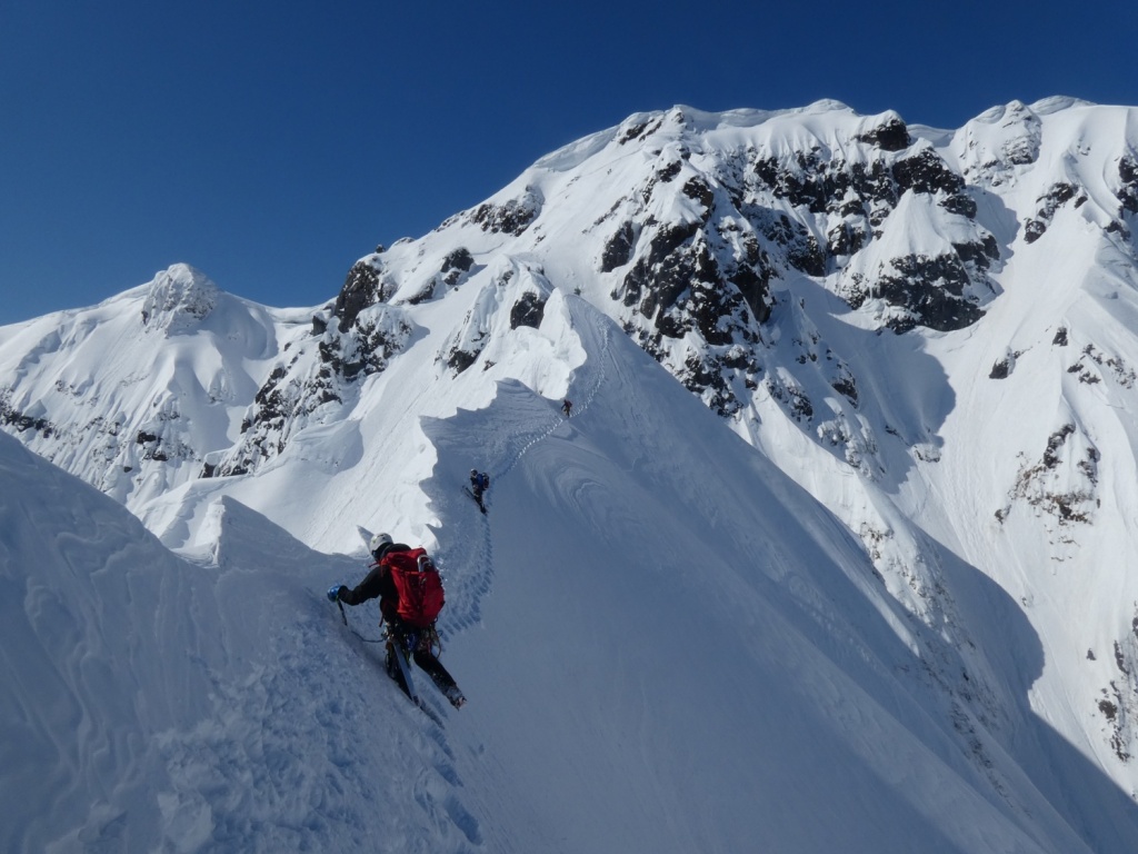 Climbers traversing knife-edge snow ridge on Tanigawa East Ridge in winter
