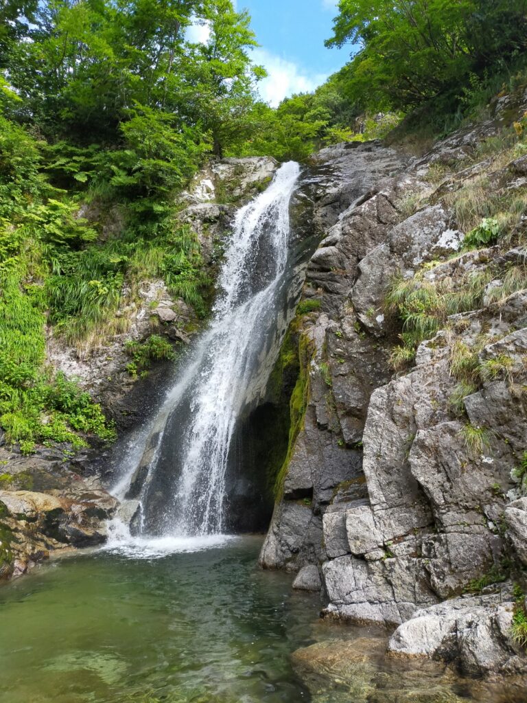 Climber ascending 17-meter waterfall staircase formation Nanatakisawa Japan