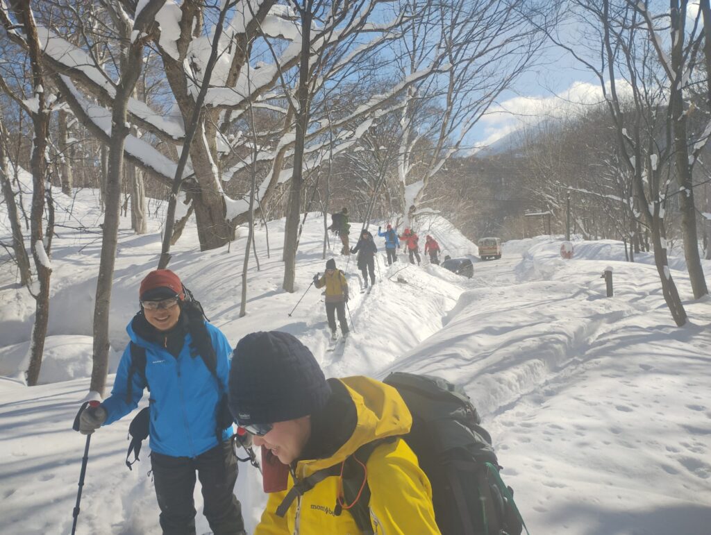 Ski mountaineering group preparing equipment at Gentaga-dake trailhead with heavy snow accumulation