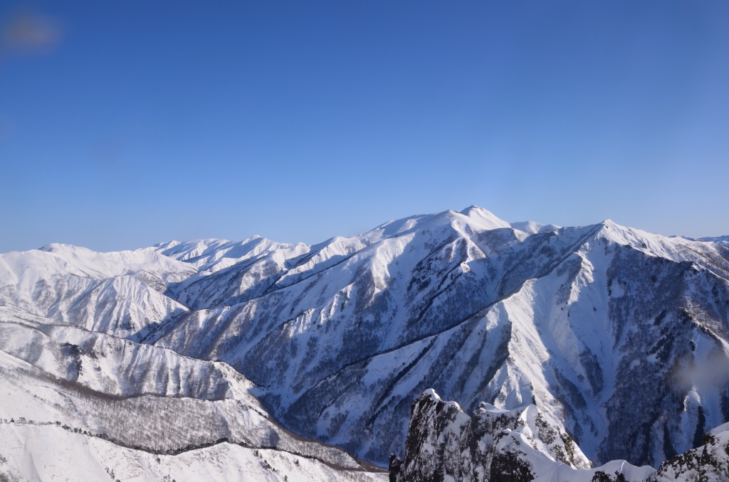 Panoramic winter view from Tanigawa ridgeline with blue sky and snowy peaks