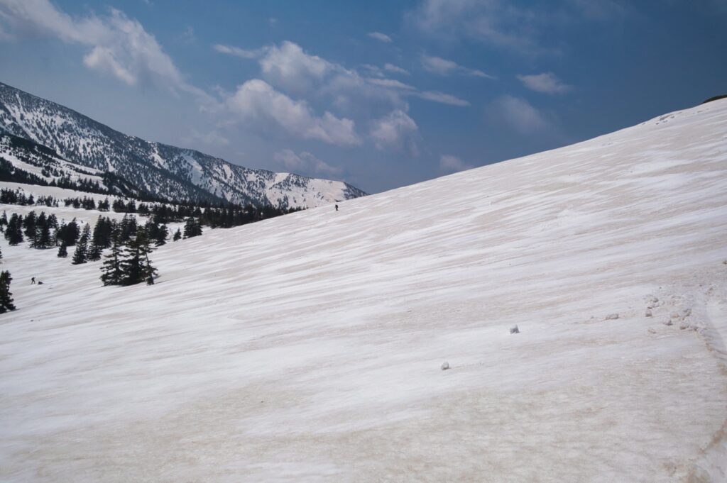 Backcountry skier descending north face of Yokodake through stop-snow conditions in Japan