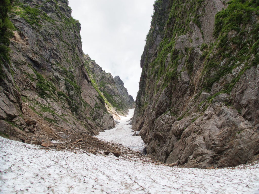 Alpine climbers ascending Ikenotan Glacier with full camping gear Mt. Tsurugi Japanese Alps