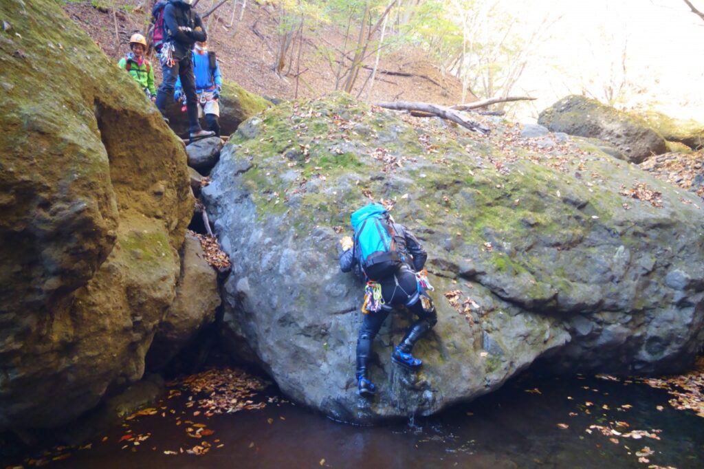 Mountain guides practicing on boulder section during stream climbing, Yakyusawa, Ura-Myogi, Japan