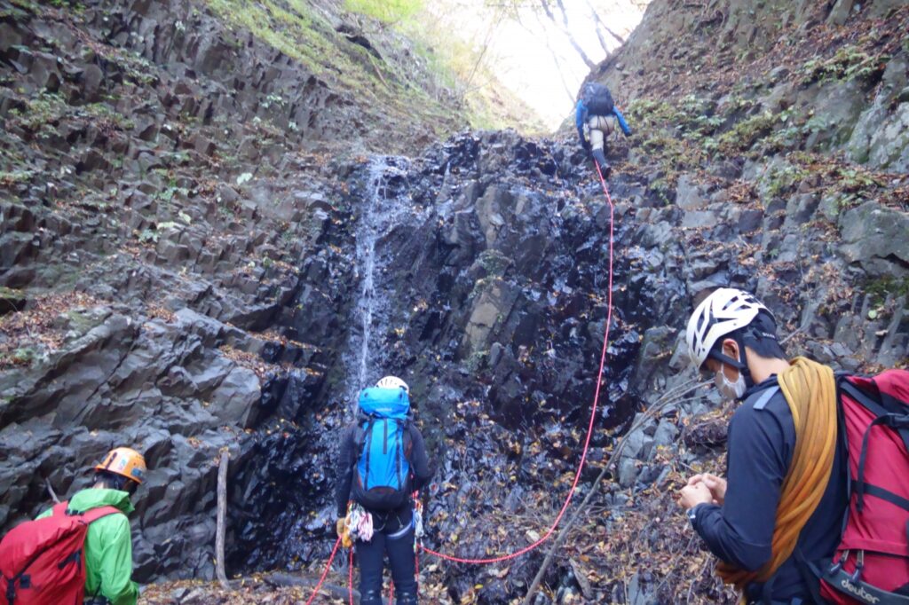 15-meter columnar basalt waterfall main crux with autumn foliage backdrop, Yakyusawa, Ura-Myogi, Japan