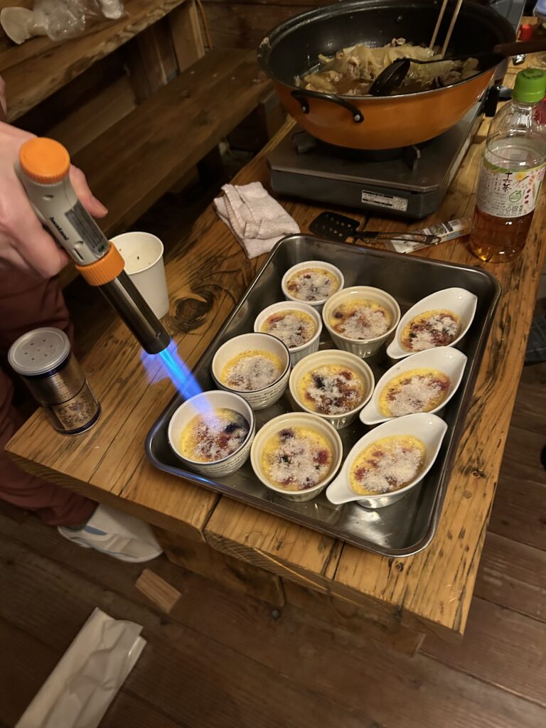 Crème brûlée being caramelized with blowtorch at mountain hut New Year party