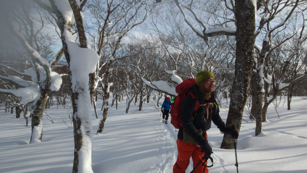 Expansive snowfield of Ichigunndaira plateau with blue sky in Funagata Mountains
