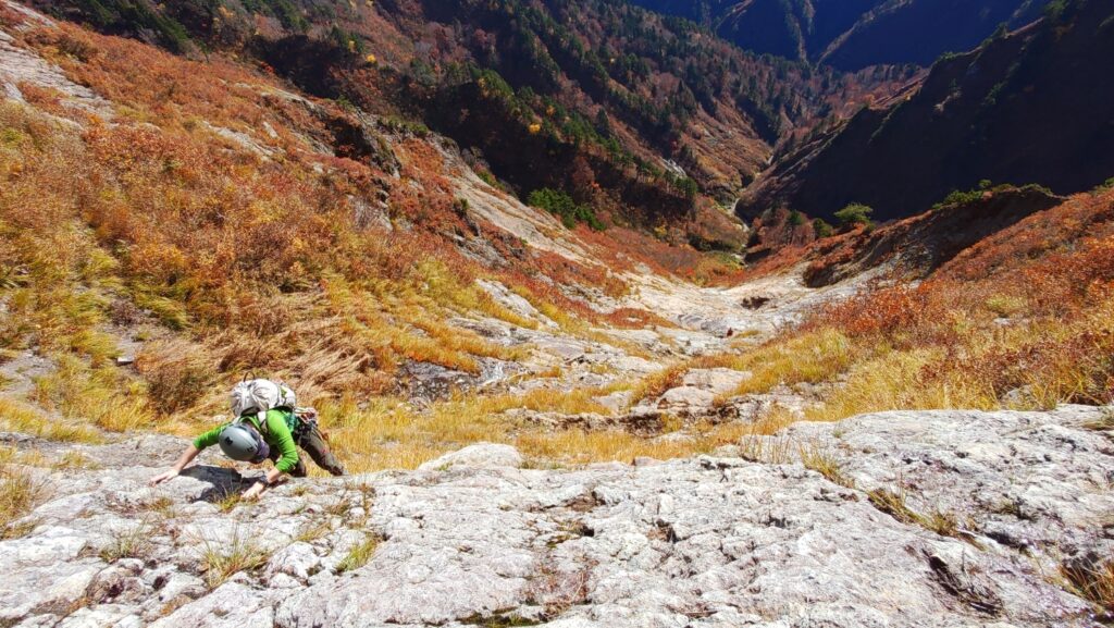 Climber on exposed granite slab Mt. Maegadake South Wall with mountain views