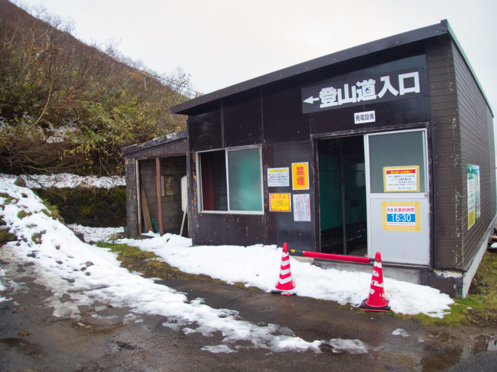 Mt. Iwaki-san 8th station parking lot with first snow dusting the upper slopes, October 2025