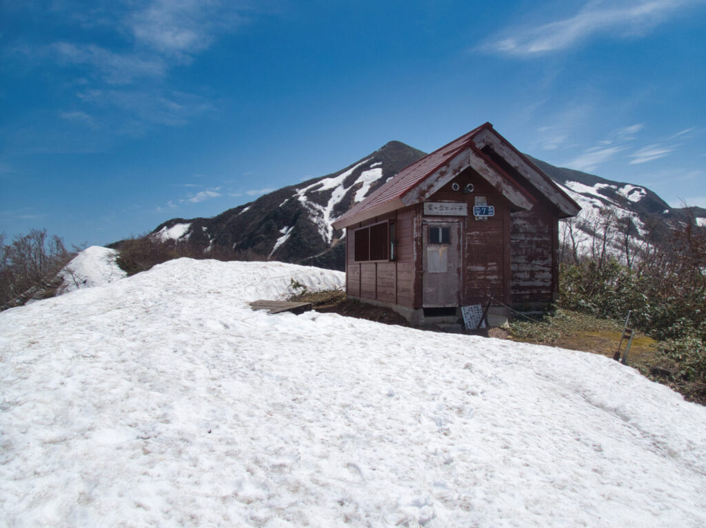 粟ヶ岳の稜線に立つ避難小屋・粟ヶ岳ヒュッテMt. Awagatake Hut, an emergency shelter on the ridge.
