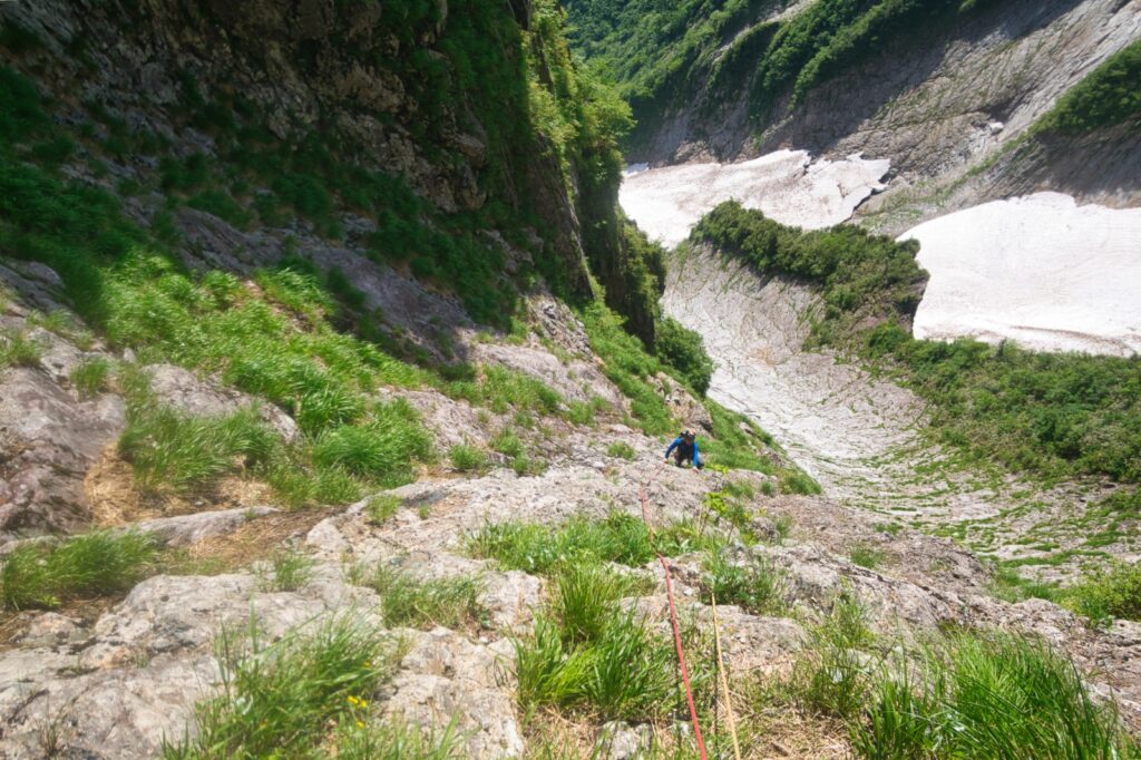  "Climber entering direct ascent route on Central Buttress, using shrubs for protection"